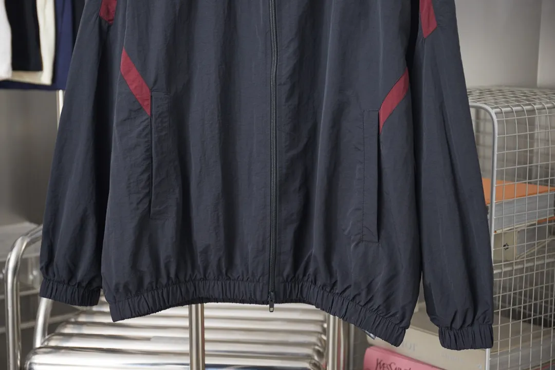 Balenciaga 𝘽𝘼𝙇𝙀𝙉𝘾𝙄𝘼𝙂𝘼 BLCG 26SS 3M black and red stitching embroidered hooded sports suit Light luxury essential item for daily commuting for men and women Correct version Welcome to compare Detailed features · Customized matt Taslan jacket fabric · The fabric has undergone a waterproof coating process · The interior is made of three-grade polyester bird's eye mesh · OS ultra-loose silhouette design · Side zipper pockets Small stand-up collar design · Internal zipper pocket design · Elastic waistband design at the hem · Customized molded hardware zipper Jacket double puller design · Tajima high-speed embroidery machine 10000 needle three-dimensional · Double side pockets on trousers · Original main mark washed tag brand packaging Color: Black Size: 46/48/50/52